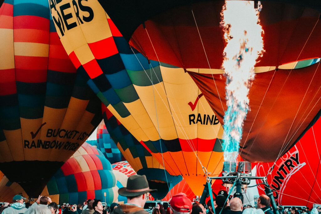 Colorful hot air balloons inflating with flames, capturing festival excitement in Albuquerque.
