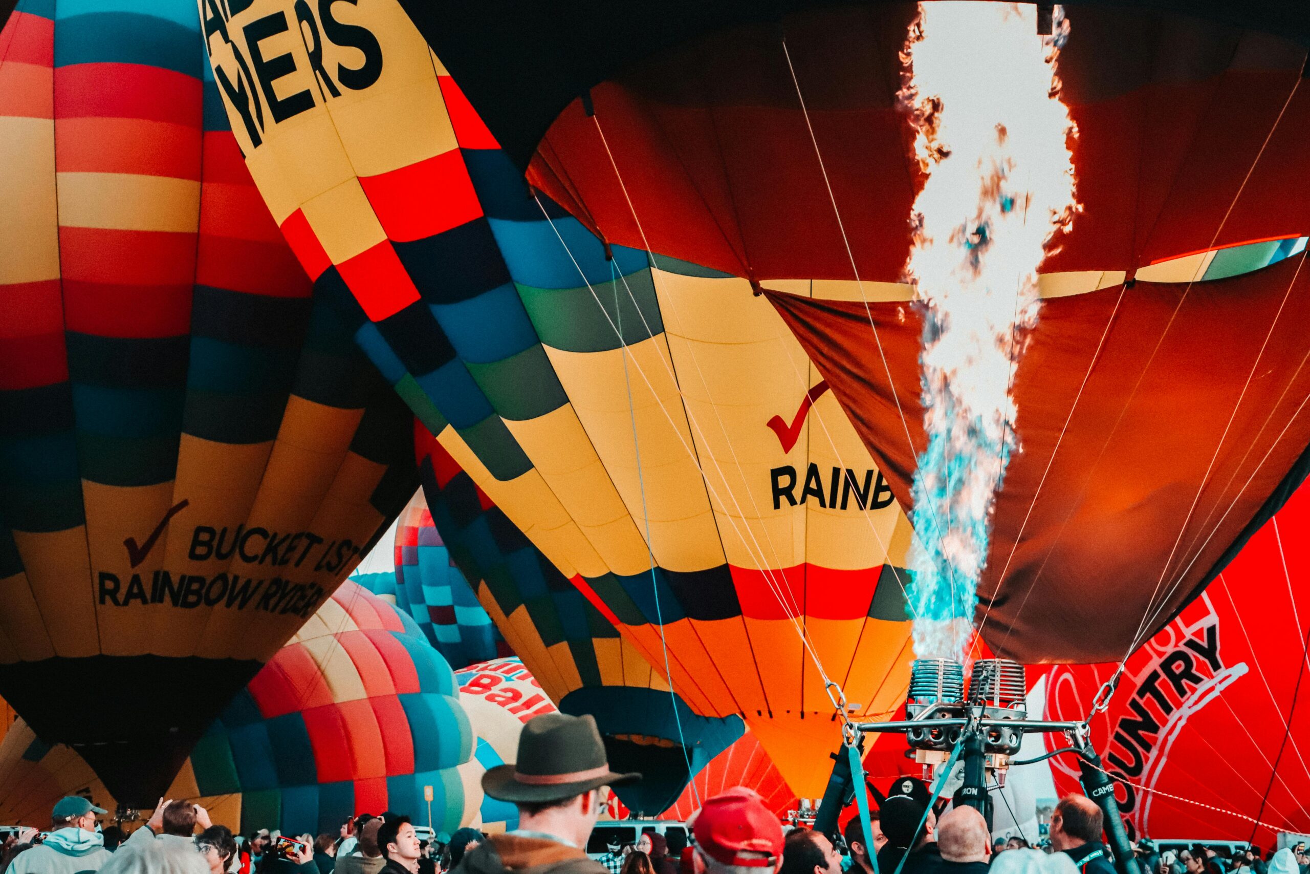 Colorful hot air balloons inflating with flames, capturing festival excitement in Albuquerque.
